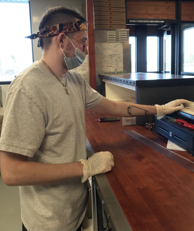 Howard’s Pizza employee Logan Razote completes a transaction on March 22, 2021.