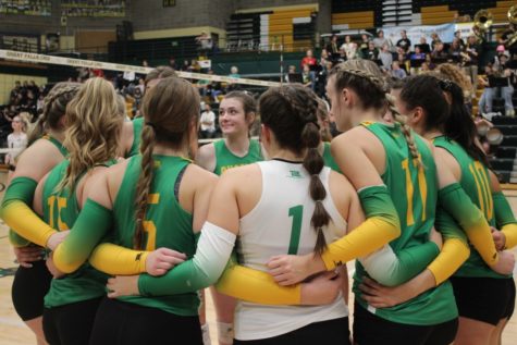 CMR Varsity Volleyball girls strategize in a group at divisionals. 