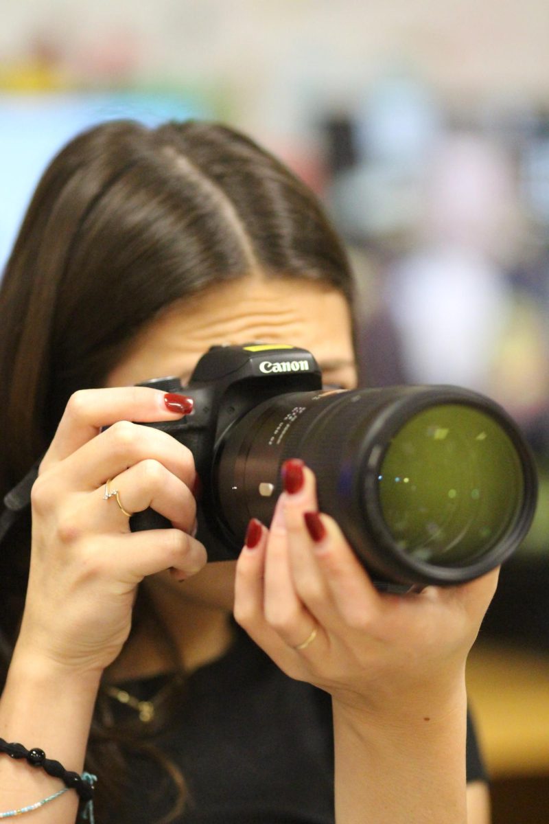 Senior photographer Ava McCarthy sets up her camera before going out to shoot on Dec. 6.