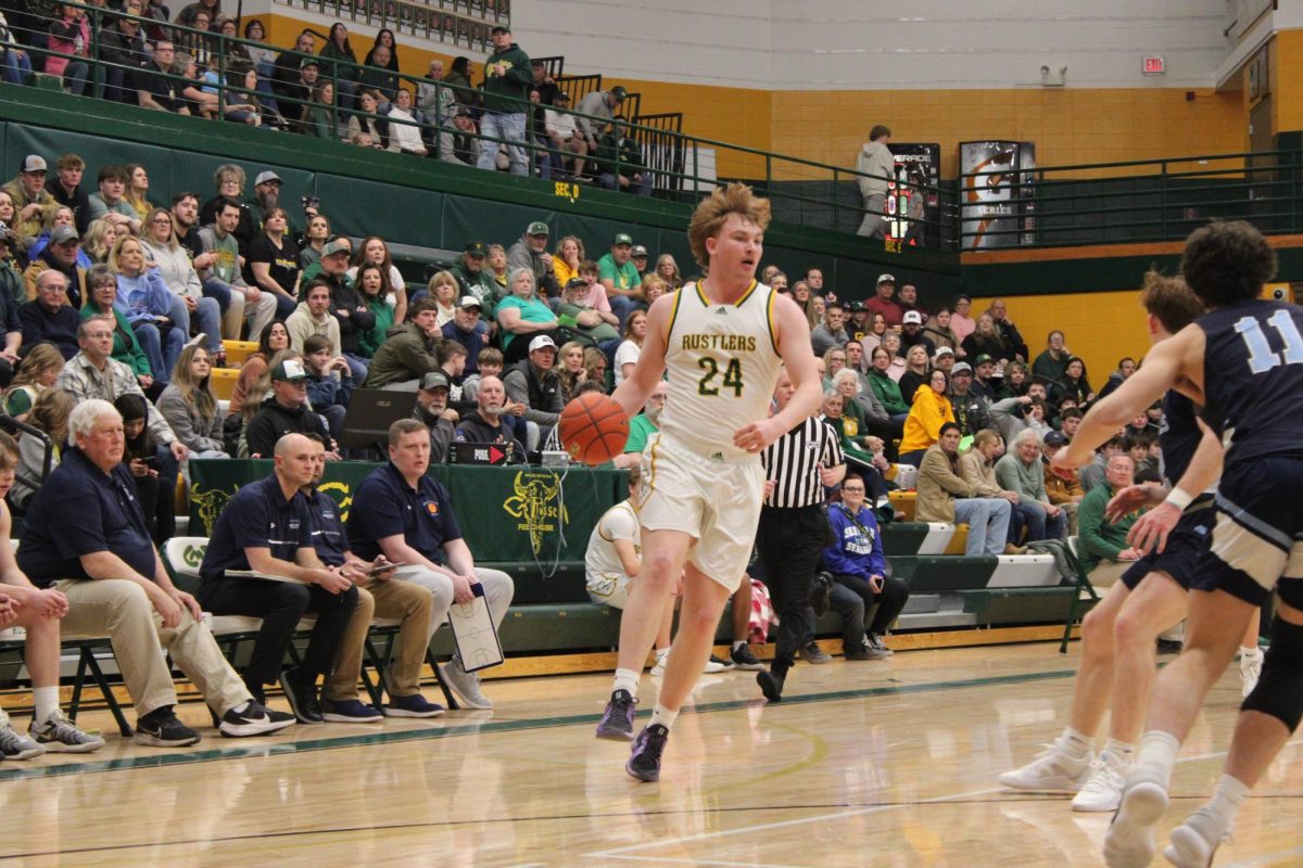 At the first crosstown game of the season on Jan. 31, senior Dean Blair takes control of the ball and looks for an opening to score. The Rustlers beat the Bison 53-38.