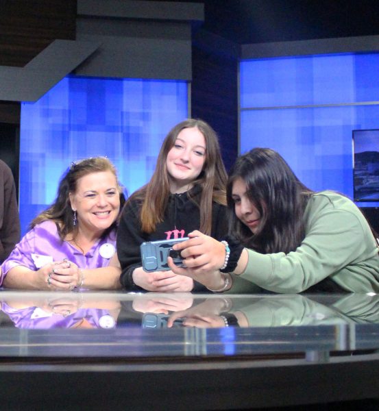 Bethe Barrett, Briana Wible work with another member of METS on a news script.