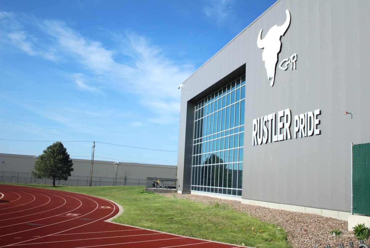 The Aux gym faces the football field as the sky reflects off the windows.